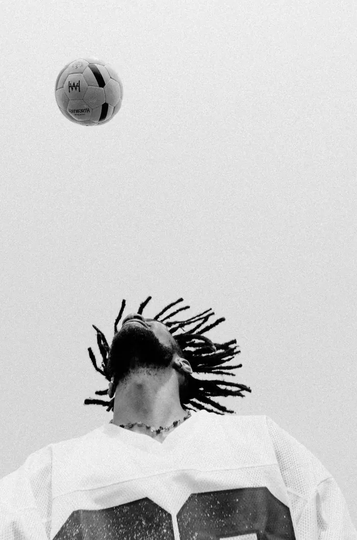 A player with his head thrown back beneath a Hayworth ball in the air, in black and white. Photograph by Kate Liddy.