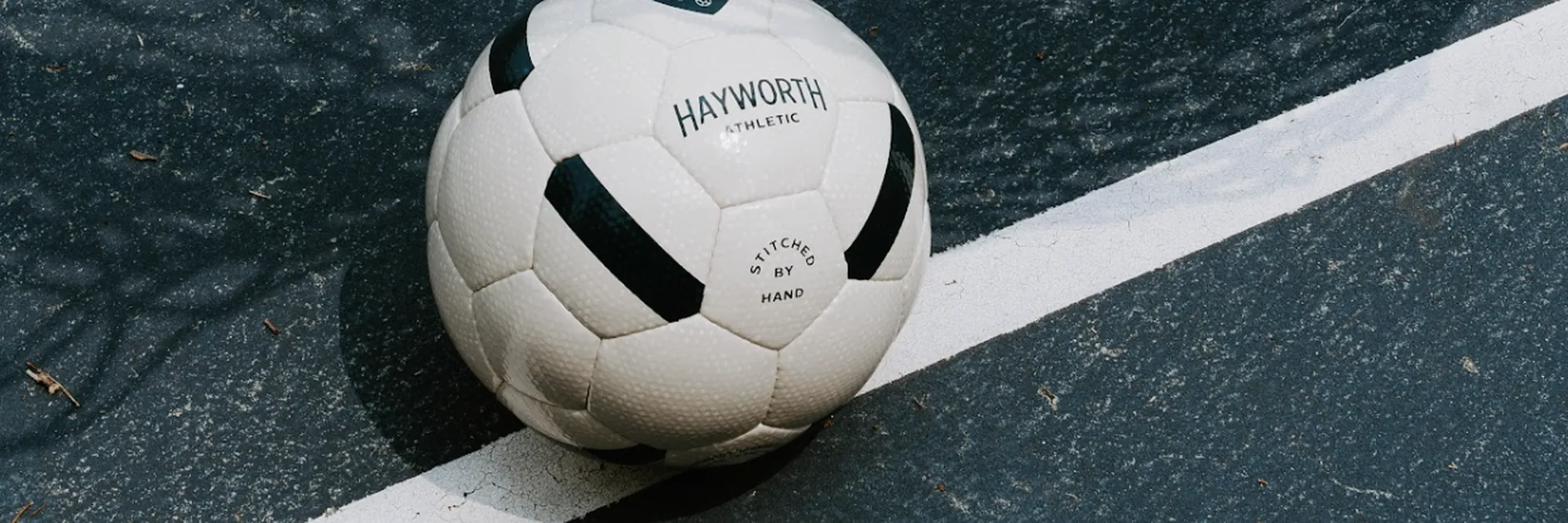 A No. 152 resting on the goal line of a blue outdoor court, the net overhead. Photograph by Kate Liddy.